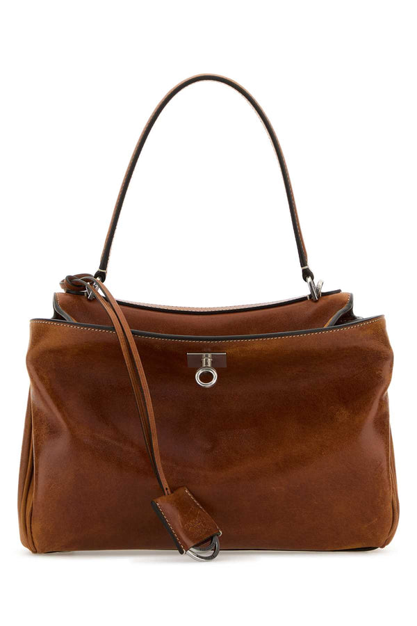 Balenciaga Handle Exterior: 100% Calf Lining: 100% Lamb Finishing: Antiqued golden metal top handle bag in brown