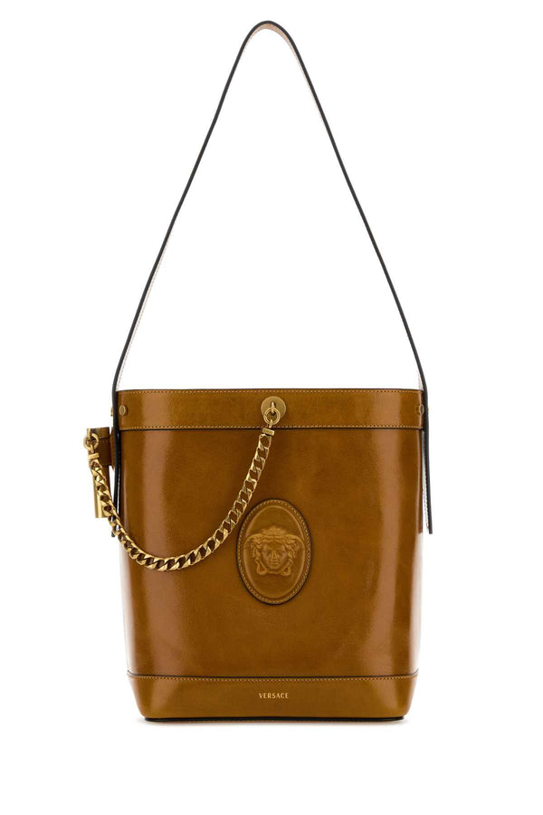 Versace Bucket Exterior: 100% Calf Leather; Lining: 100% Leather; Finishing: Antiqued golden metal bucket bag in brown