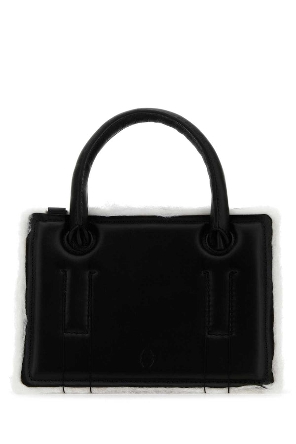 Dentro Exterior: 100% Leather top handle bag in black